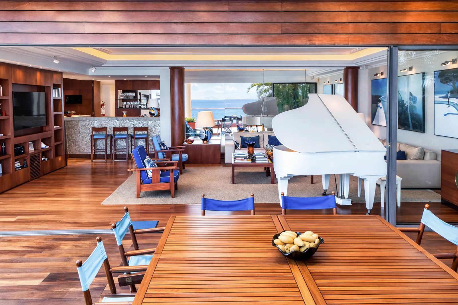 White grand piano at the entrance to the terrace, wood ceiling above