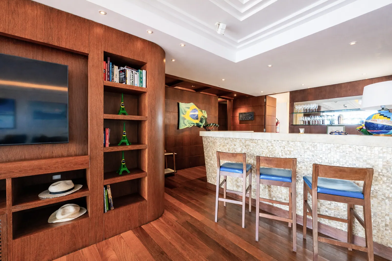 Bar counter with stools, shelving and television behind