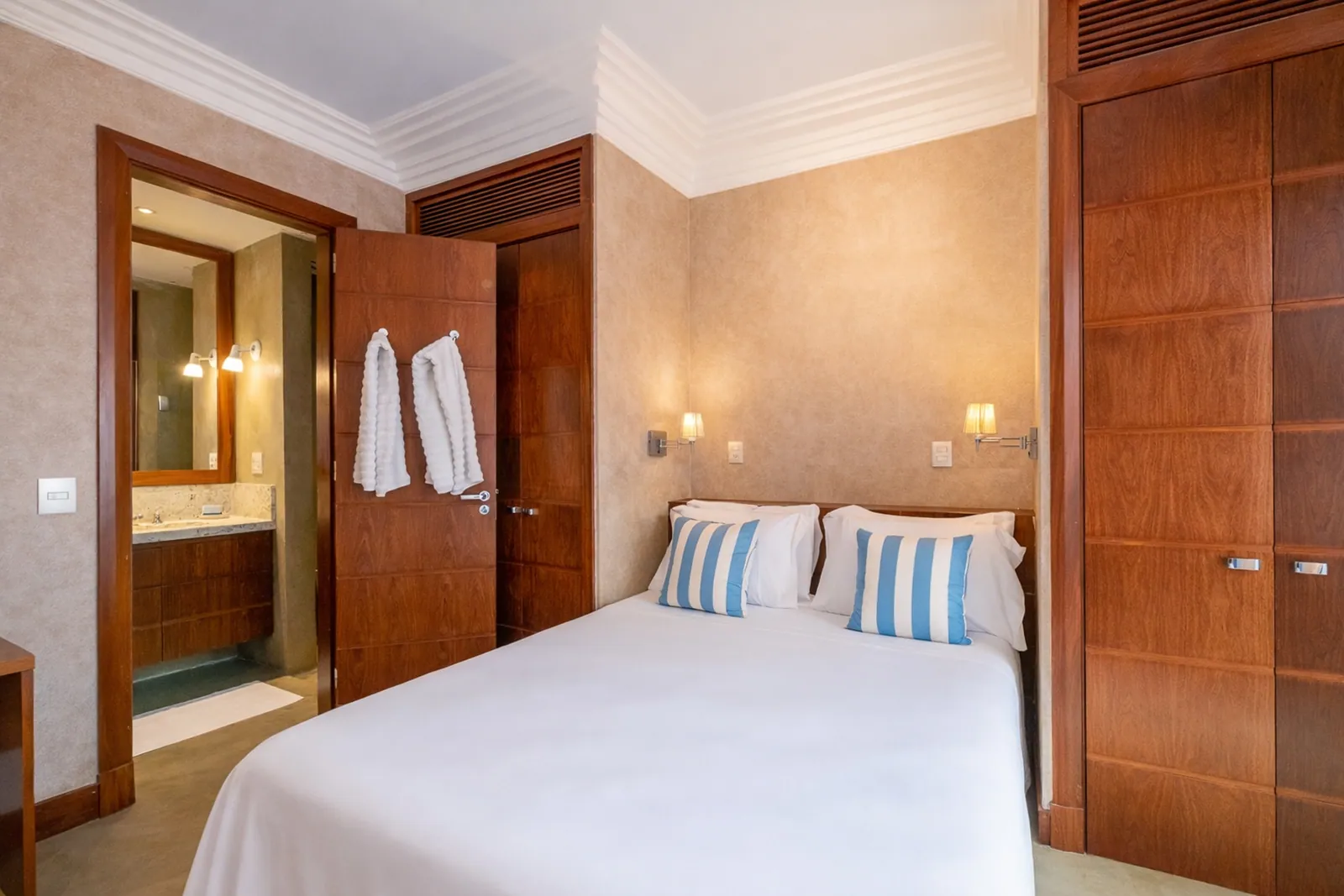 Bedroom with its bathroom open beyond the doorway