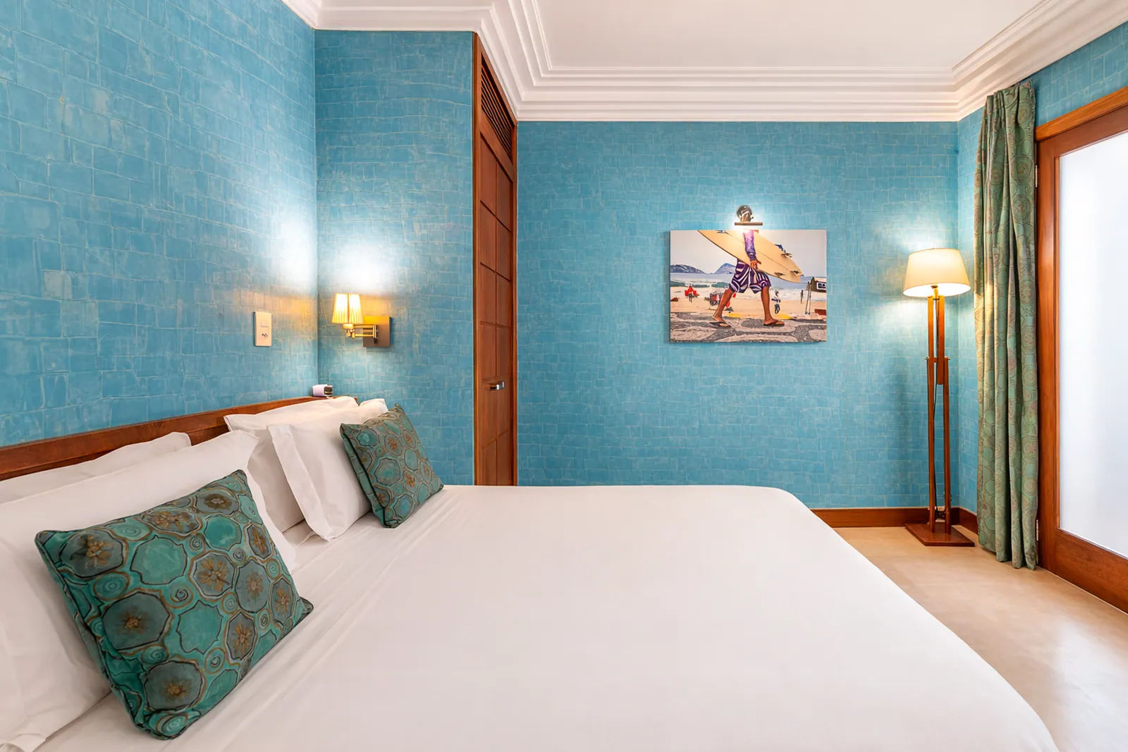 Turquoise bedroom with reading lamp and framed photograph