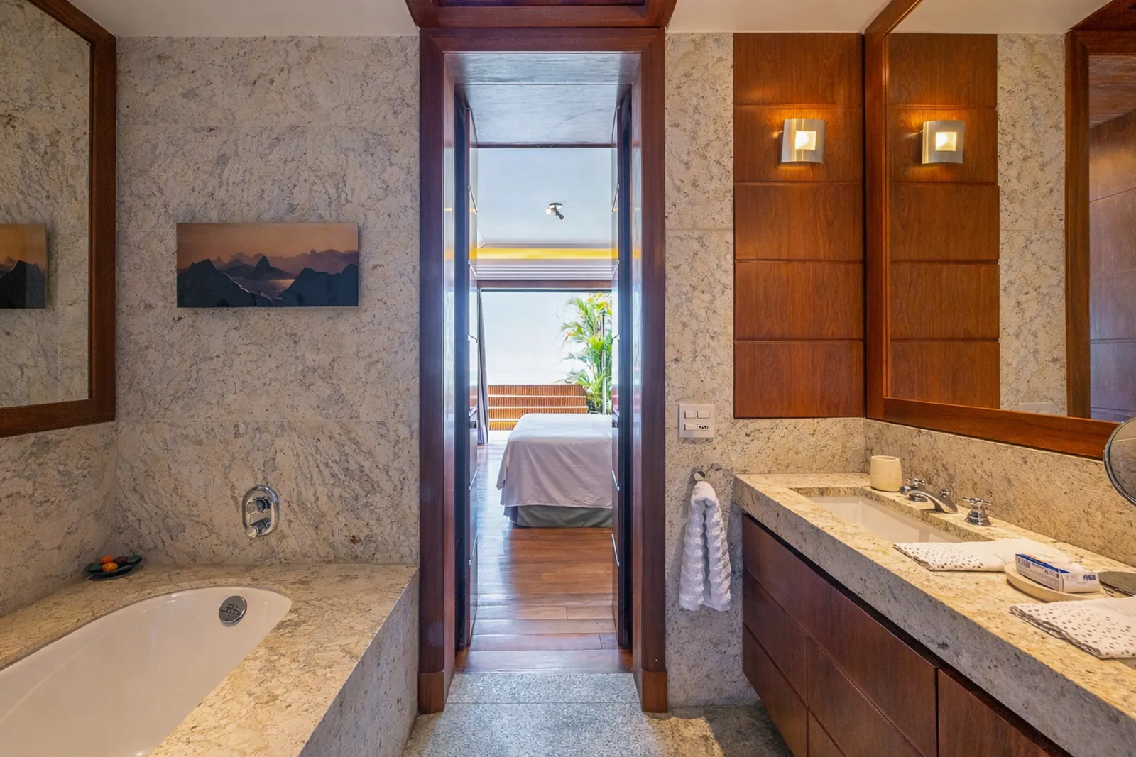 Marble bathroom with bathtub, the bedroom visible through the door