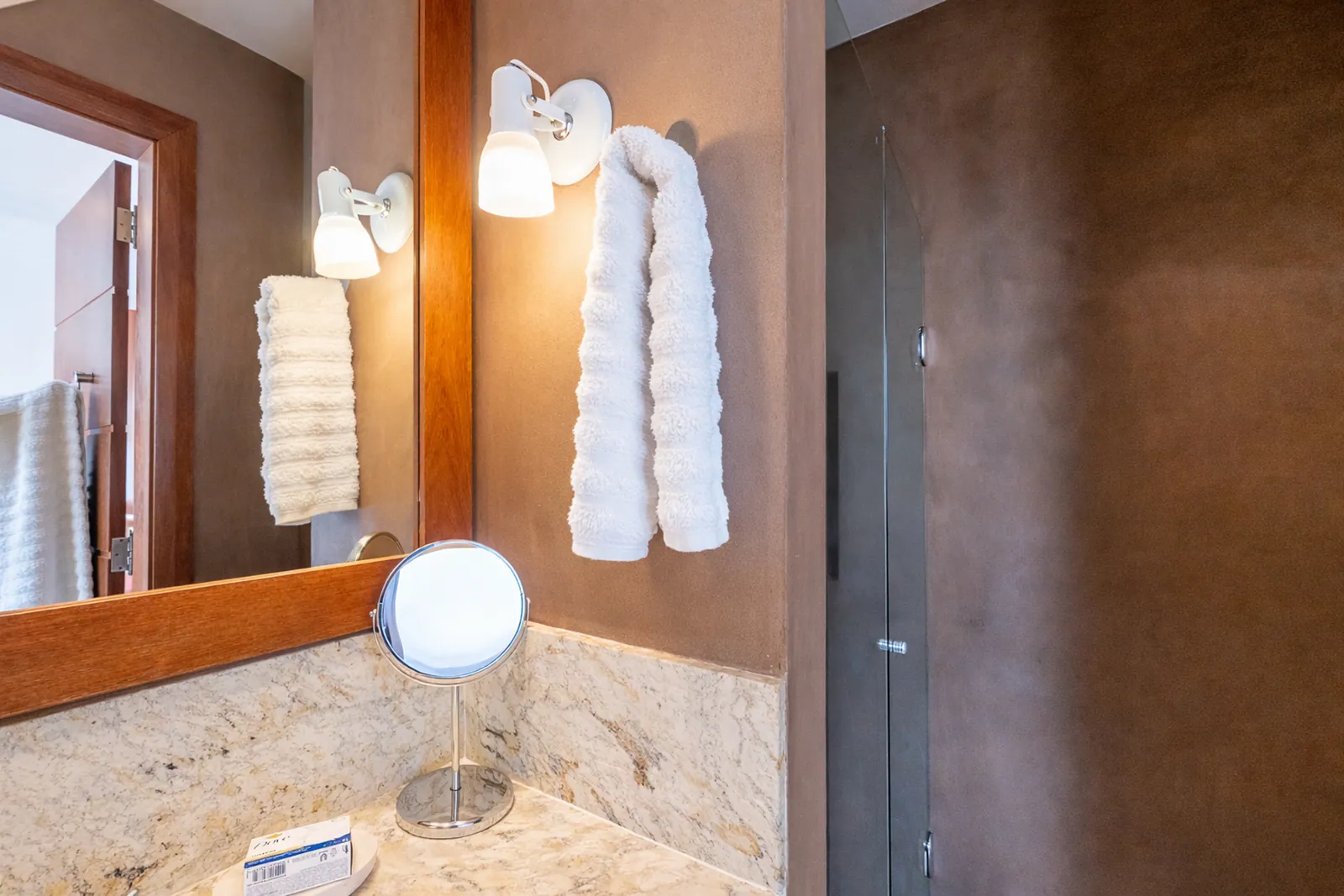 Bathroom vanity in marble with folded towels and mirror