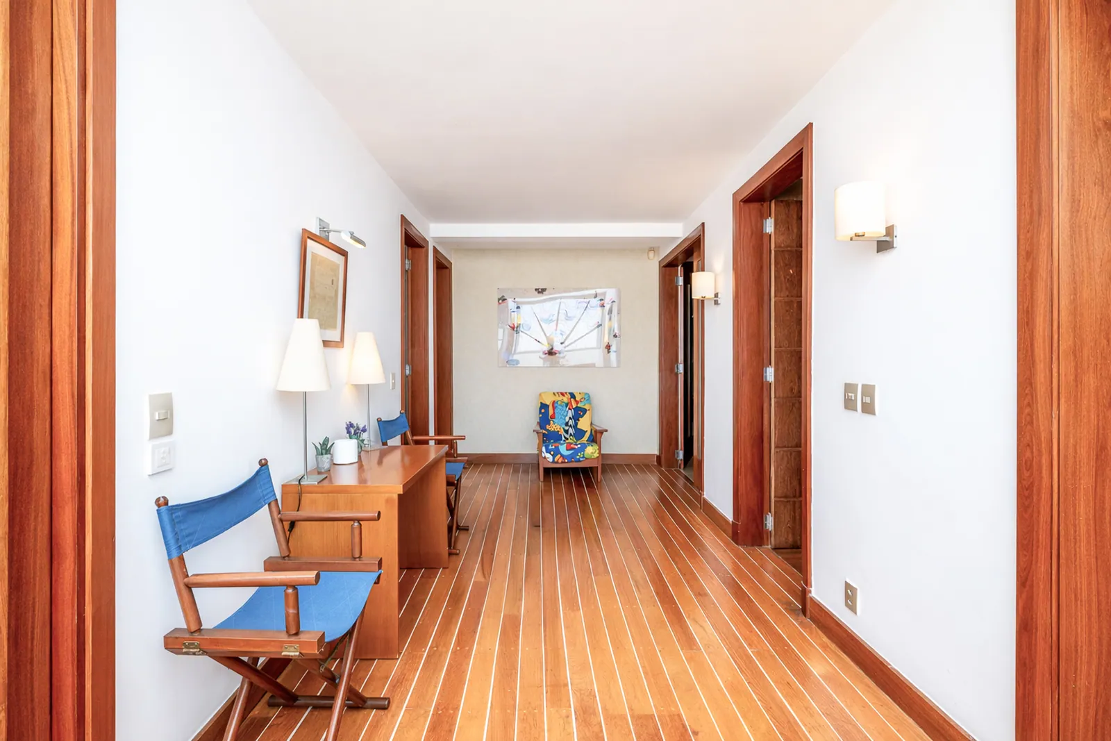 Hallway with writing desk and canvas chairs, wood floor throughout