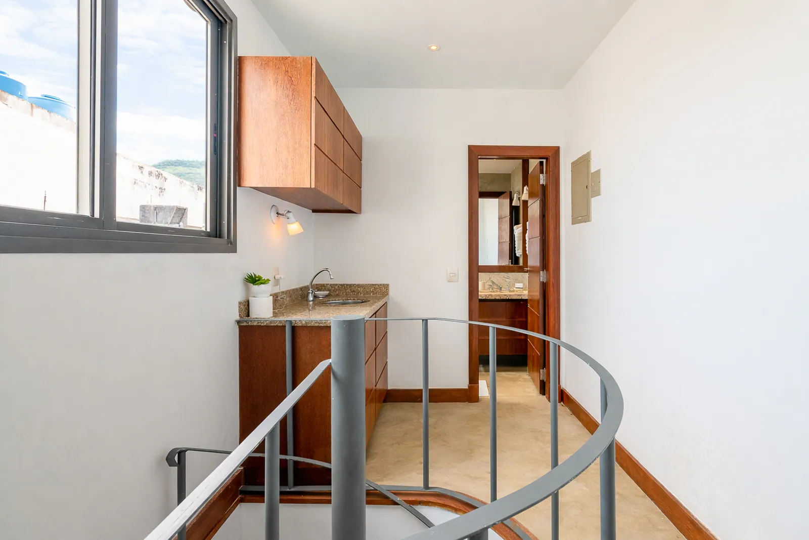 Spiral staircase to the upper floor, small kitchen alongside