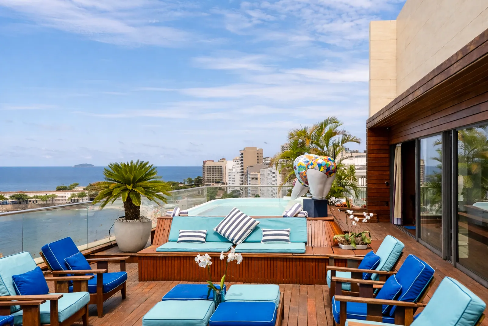 Sun loungers and palms around the pool, the ocean ahead