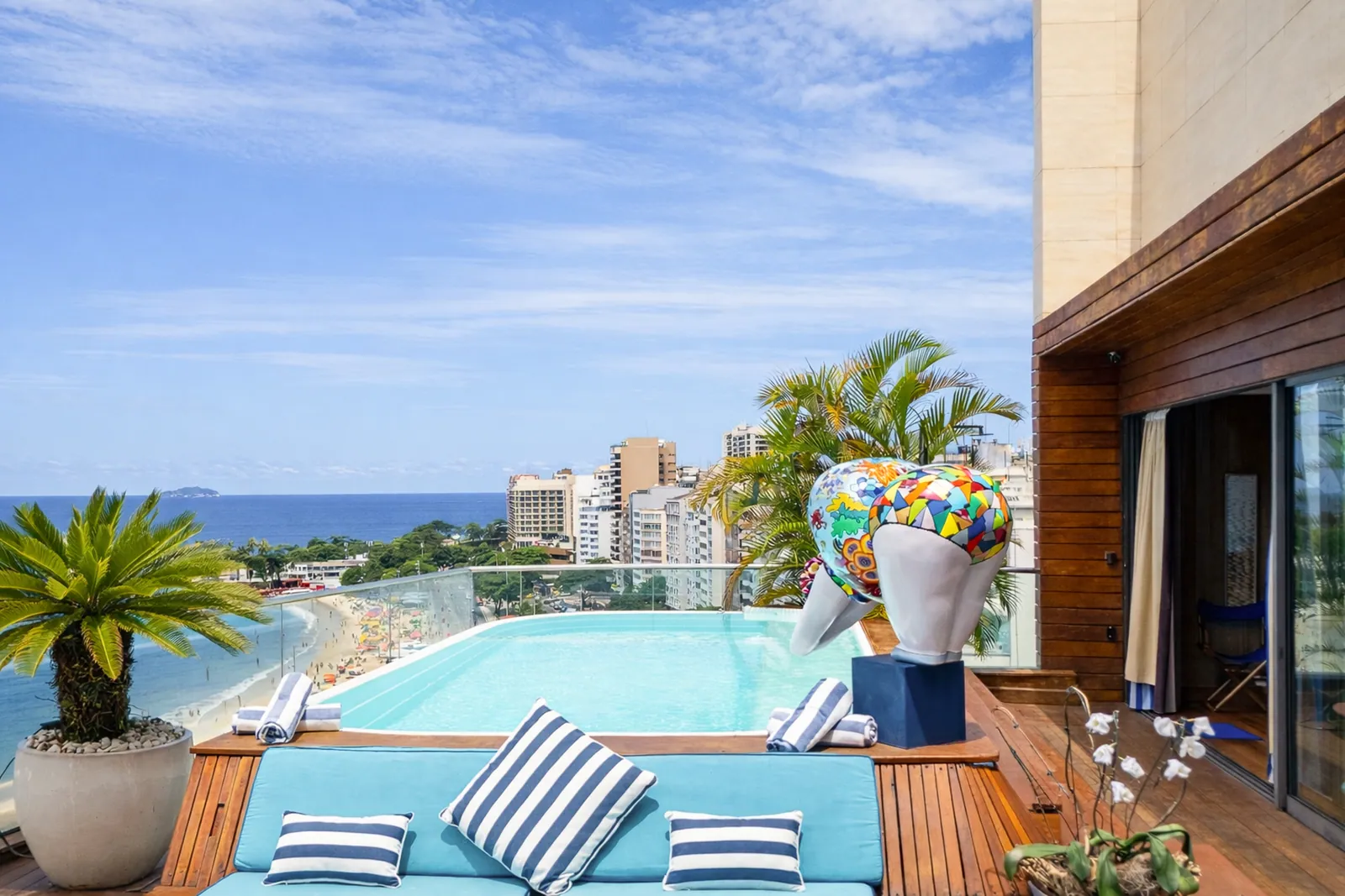Cushioned seating on the pool deck, the bay in the distance
