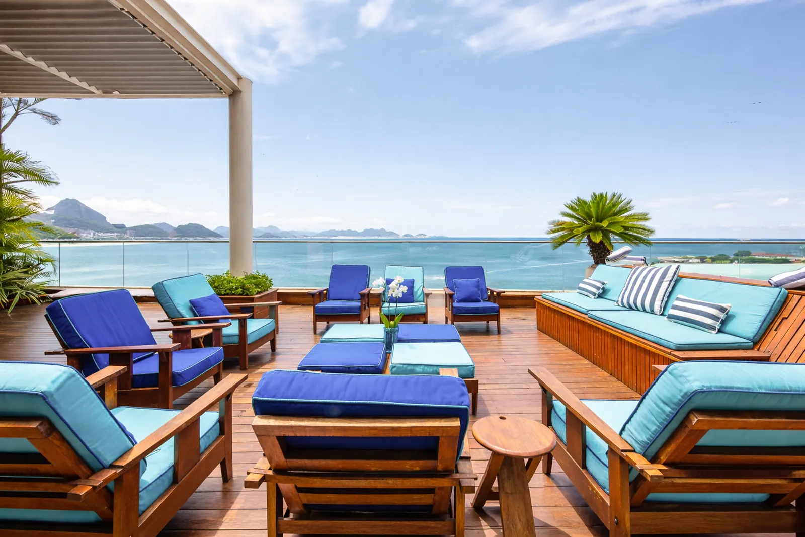 Blue loungers lined along the terrace, palms behind