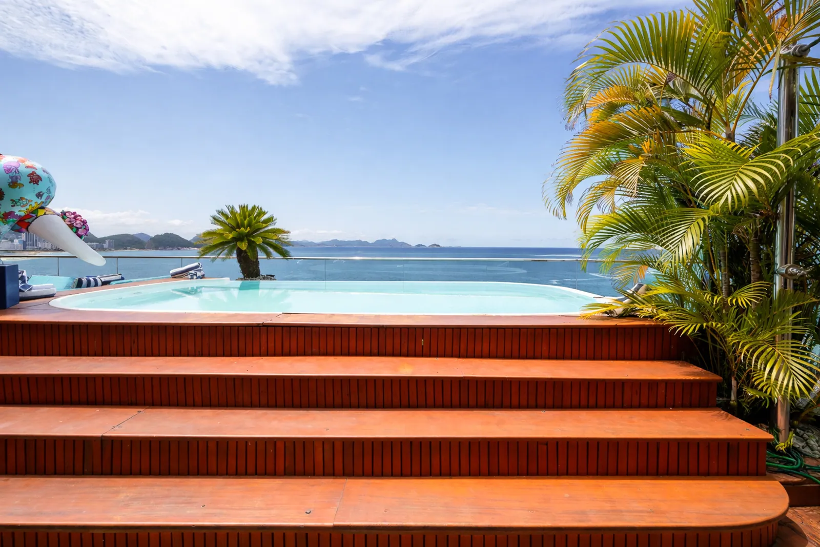 Hot tub set into the wooden deck, palms and open sea beyond