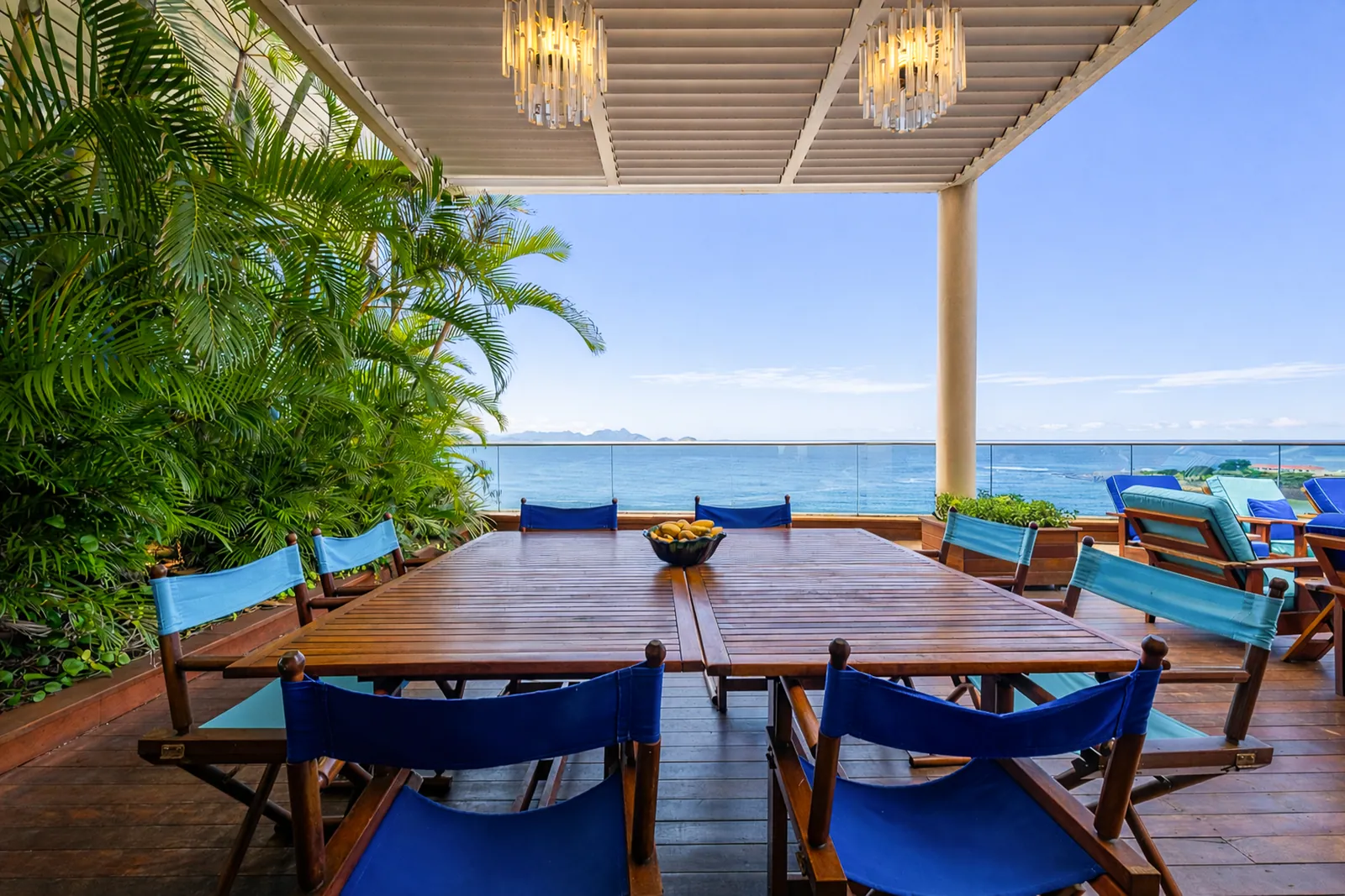 Outdoor dining table under the canvas canopy, ocean beyond
